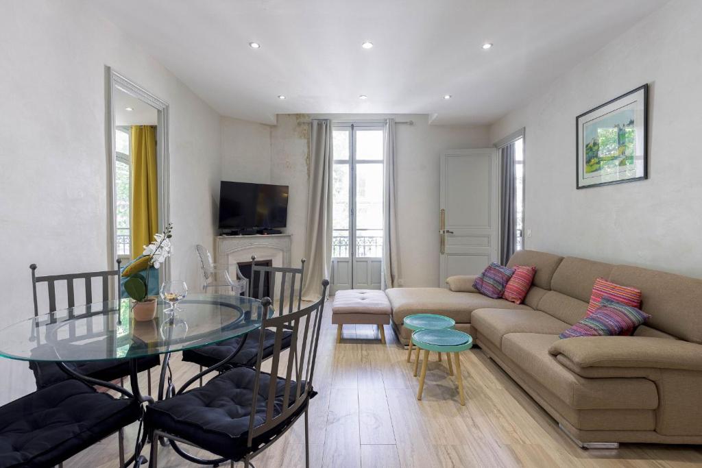 un salon avec un canapé et une table en verre dans l'établissement 13 Boulevard Carnot by Halldis, à Cannes