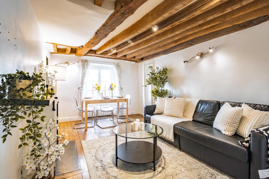 un salon avec un canapé noir et une table dans l'établissement Apt 6 Guests Charme Opera de Paris, à Paris