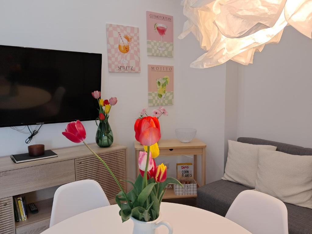 ein Wohnzimmer mit einer Vase mit Blumen auf einem Tisch in der Unterkunft OLTREMARE holiday home in Catania