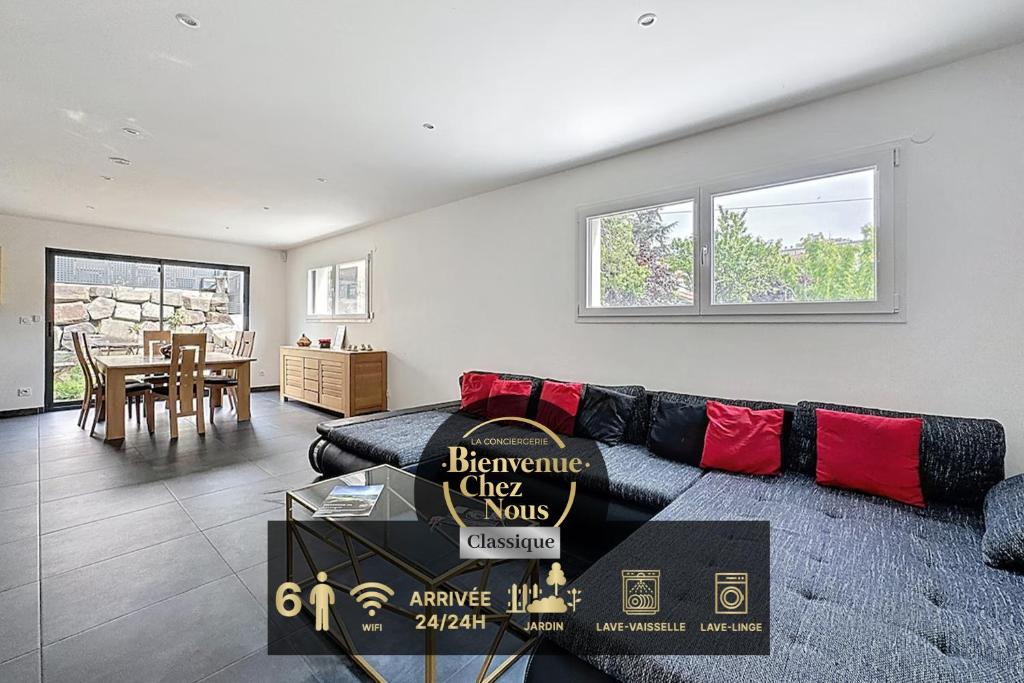 - un salon avec un canapé noir et des oreillers rouges dans l'établissement Maison spacieuse tout équipée Dolet, à Clermont-Ferrand