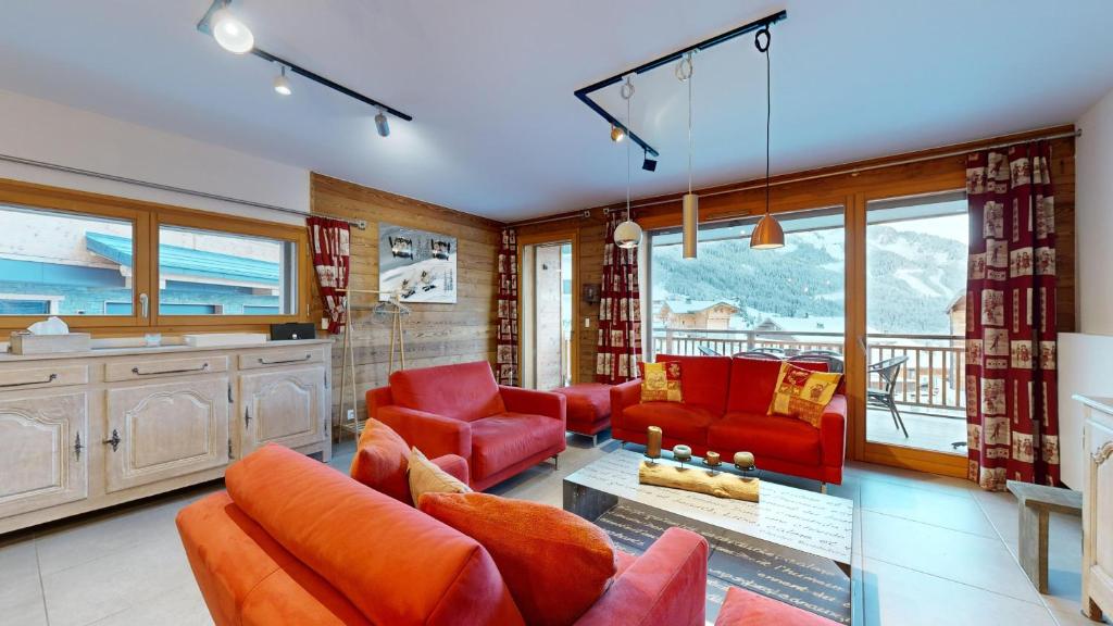 Il comprend un salon doté d'un mobilier rouge et d'un balcon. dans l'établissement Cremaillere CL201 MODERN & CENTER 8 Pers, à Châtel