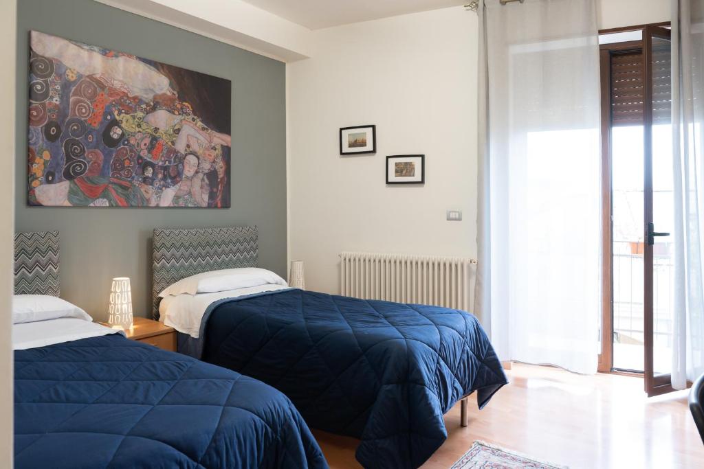 sypialnia z 2 łóżkami i obrazem na ścianie w obiekcie B&B Bella Vista w mieście Valguarnera Caropepe