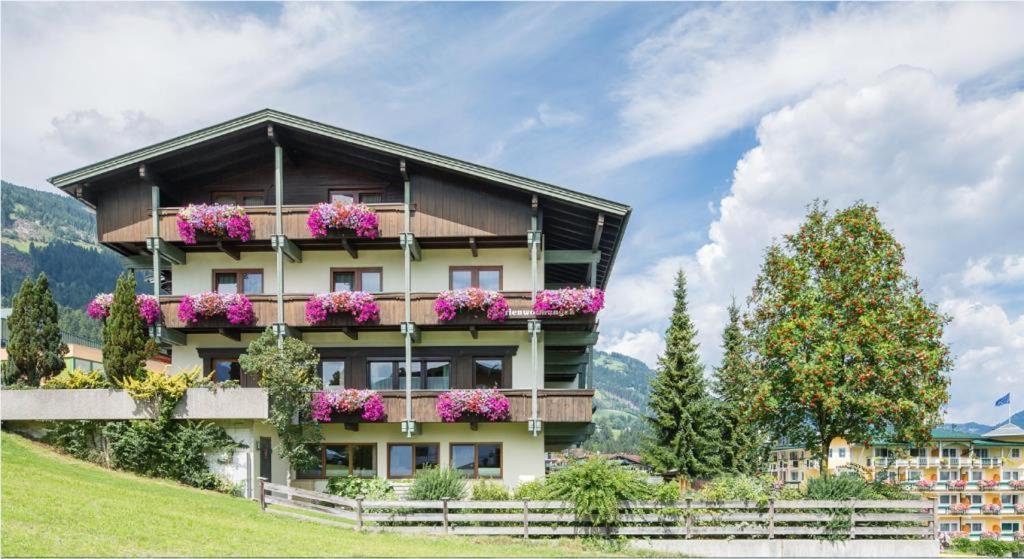 a building with flowers on the balconies on a hill at Ferienwohnungen Egger in Fügen