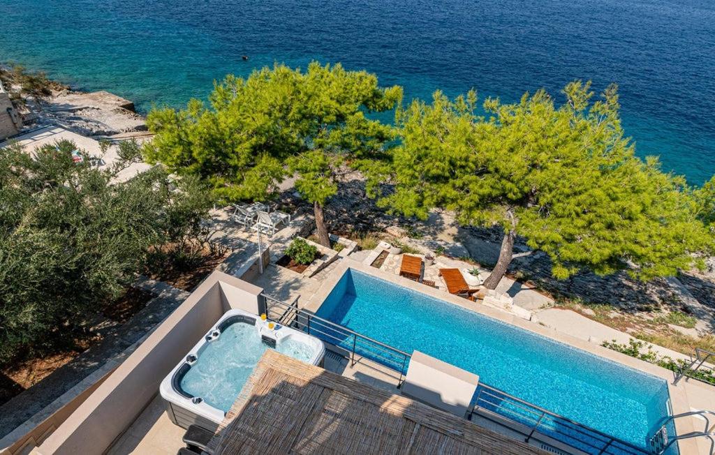 an aerial view of a swimming pool and the ocean at Villa Rania - Korcula by Villas Guide in Blato