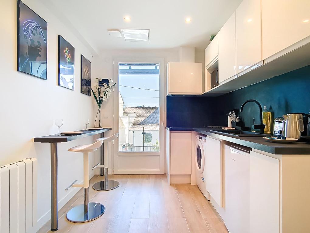 a kitchen with a washer and dryer in it at Suite Street Art - Appartement central in Argenteuil