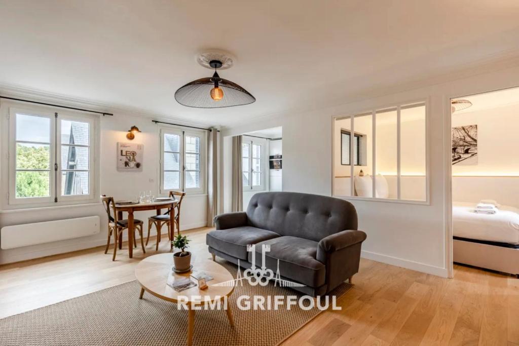 un salon avec un canapé et une table dans l'établissement La Petite Source - Downtown Honfleur - 2P, à Honfleur