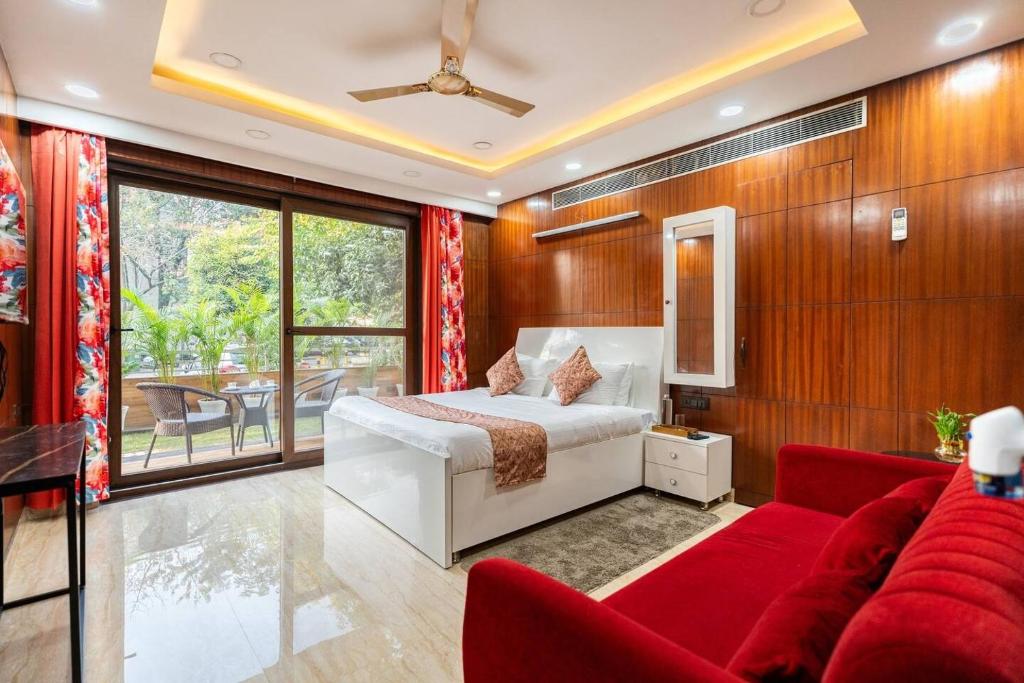 グルガオンにあるTIM Sector 51, ARTEMIS HOSPITAL 1 min walk, FORTIS & MEDANTA 4 mins driveのベッドと赤いソファのある寝室