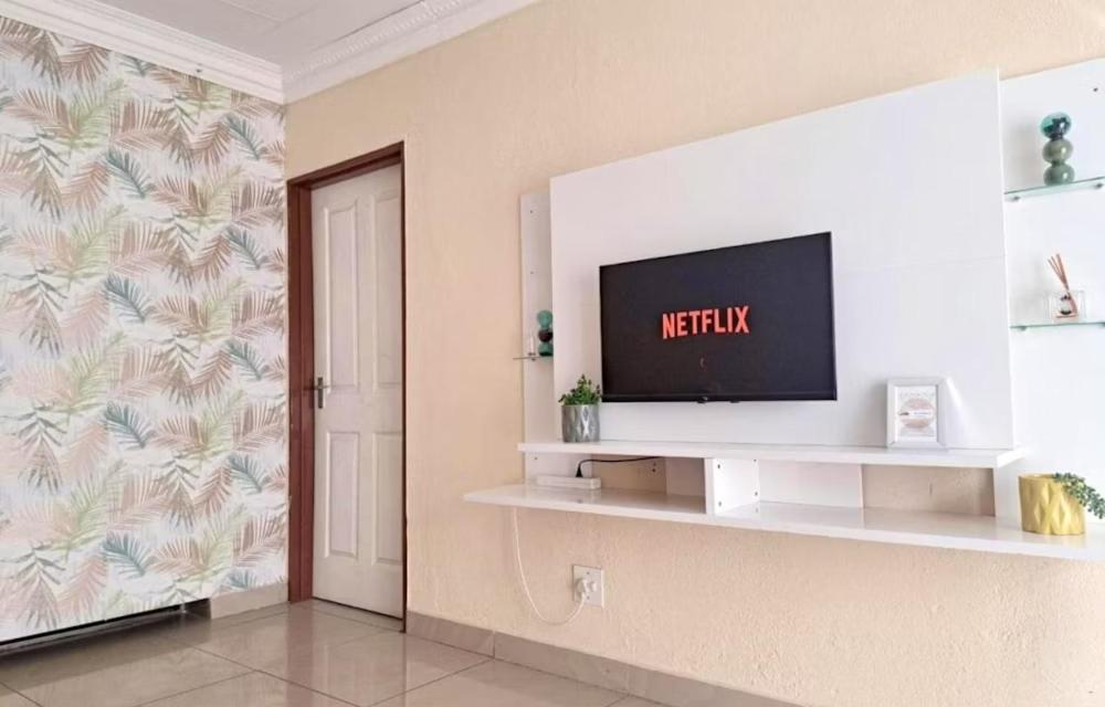 a living room with a television on a wall at C-rane guesthouse in Phalaborwa