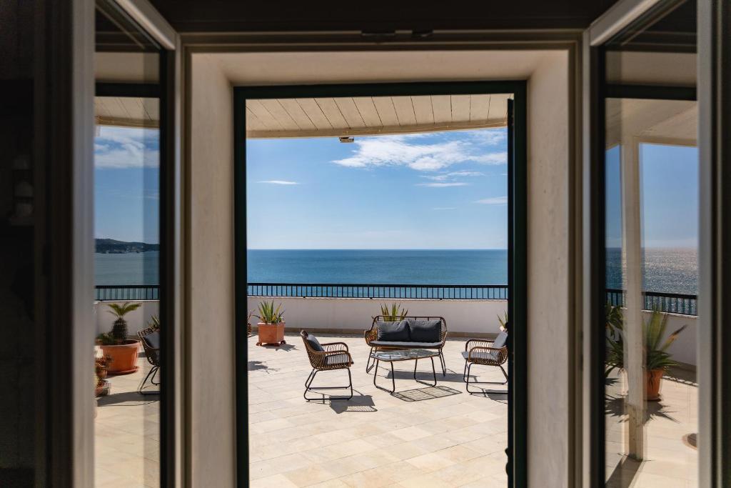 a sliding glass door to a patio with a view of the ocean at Casa sul Mare by Rentbeat in Vieste