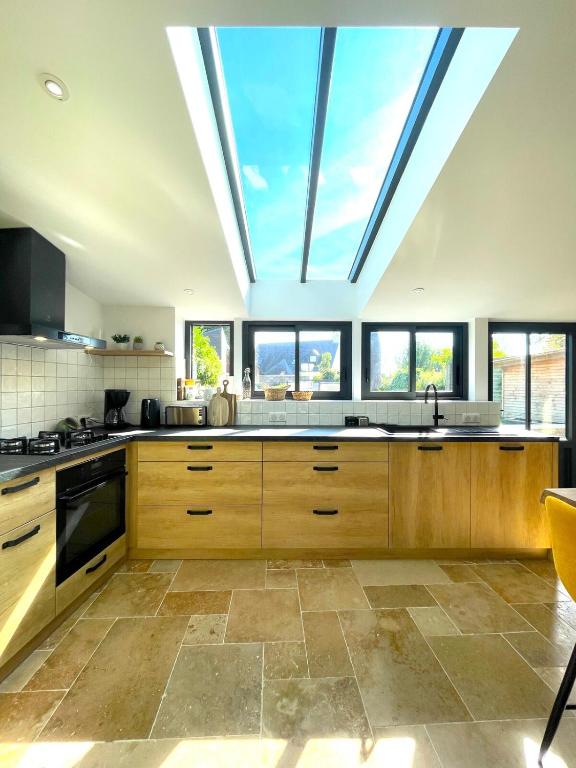 une grande cuisine avec une grande lucarne au plafond dans l'établissement Charmante Maison Rustique, à Piriac-sur-Mer