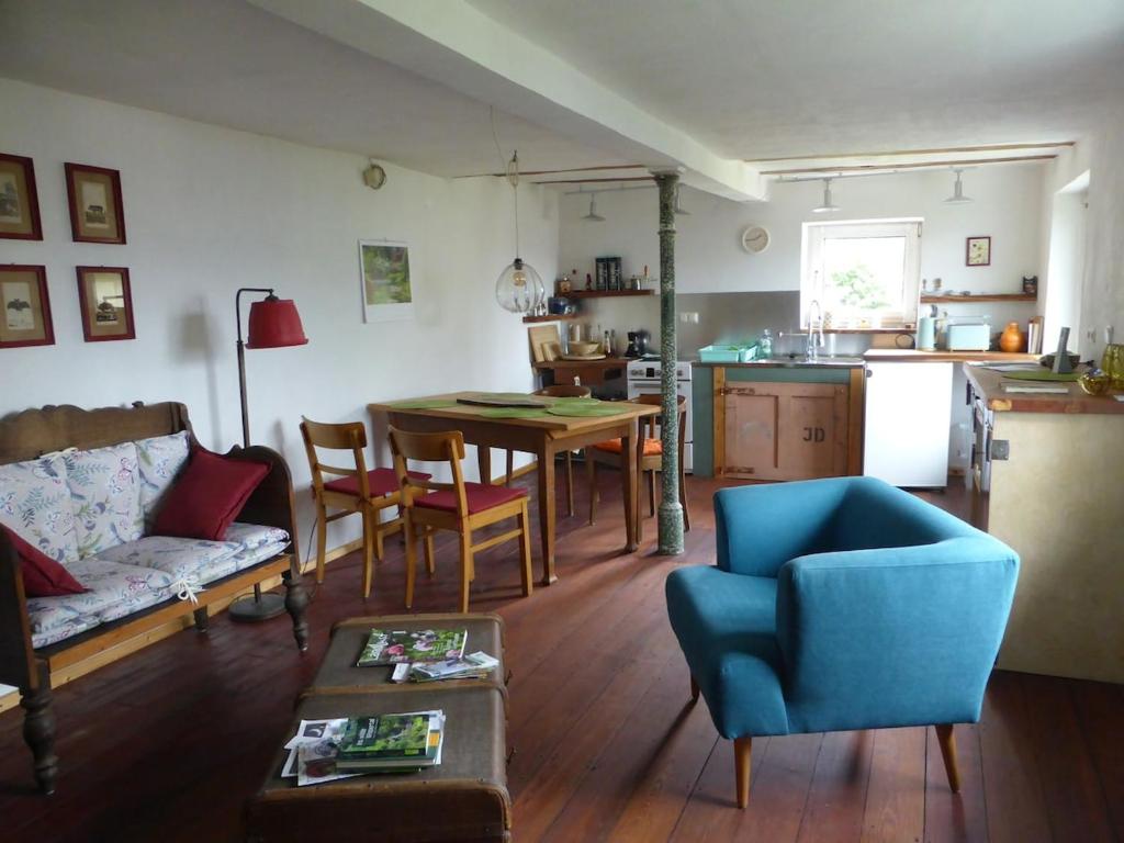 a living room with a blue couch and a table at Upcycling Ferienhaus in Roth