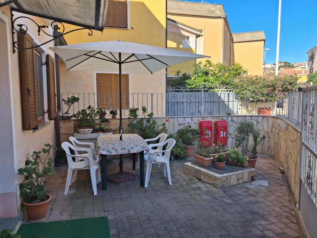 une table et des chaises avec un parasol sur une terrasse dans l'établissement Casa Silvana Relax e Mare nel cuore di Sant'Antioco, à SantʼAntìoco