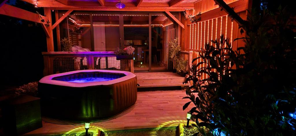 - un bain à remous au milieu d'une terrasse la nuit dans l'établissement La Luna - Tiny House Spa - Romantique & Nature, à Saint-Yan