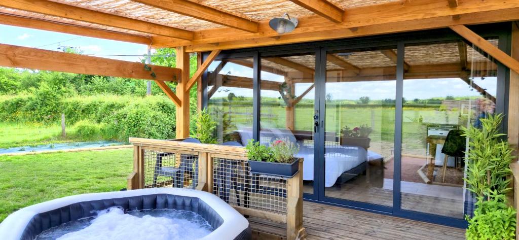 d'une terrasse avec un bain à remous. dans l'établissement La Luna - Tiny House Spa - Romantique & Nature, à Saint-Yan