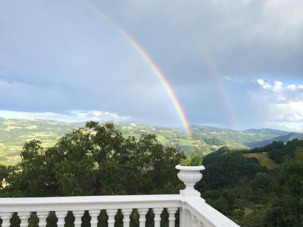 un arcobaleno su un balcone con ringhiera bianca di Eremo Pace e Gioia a Castino