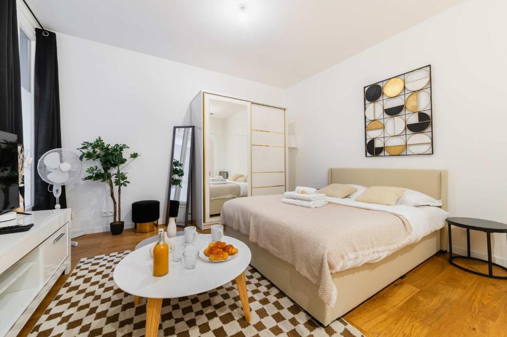 une chambre blanche avec un lit et une table dans l'établissement Studio agreable et bien placee - Paris 18 - 2P, à Paris