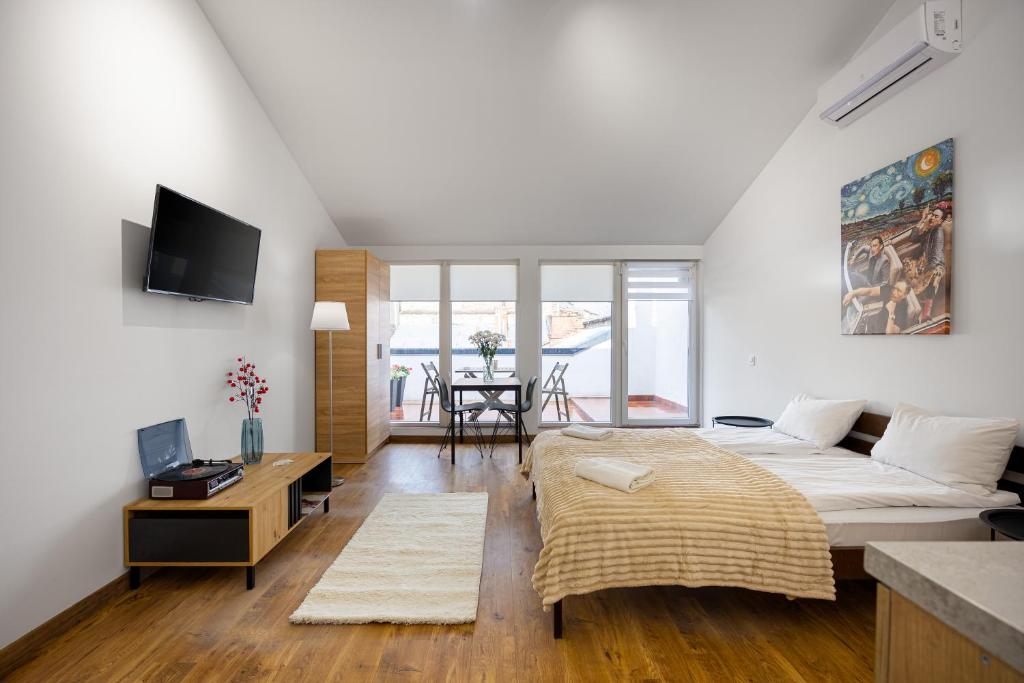 a bedroom with a bed and a living room at Апартаменти на Площі ринок 3 in Lviv