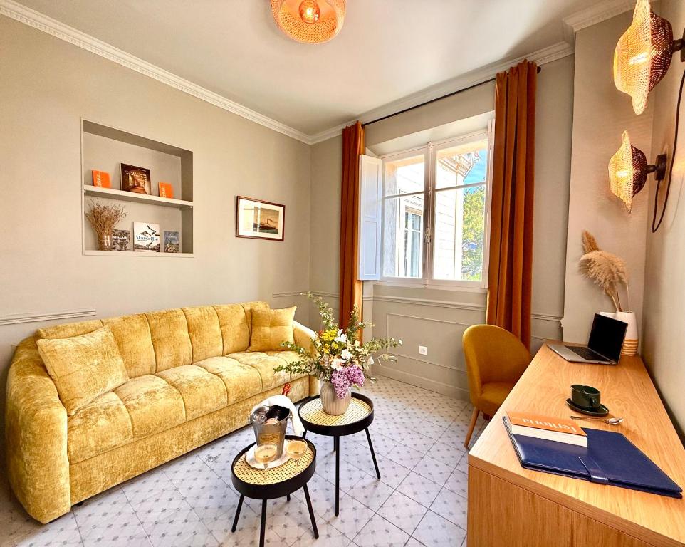 a living room with a yellow couch and a table at Boutique Hôtel Château Beaupin Restaurant & Wellness in Marseille