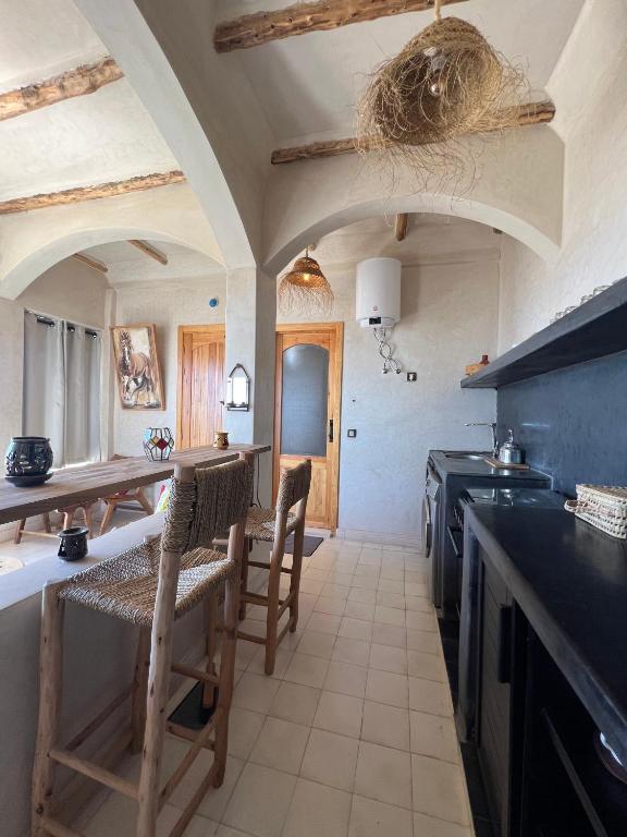 a kitchen with a table and chairs in a room at SurfAppart Morocco in Tamraght Ouzdar