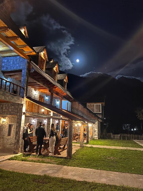 a group of people standing outside of a building at night at Bujtina Harusha in Theth