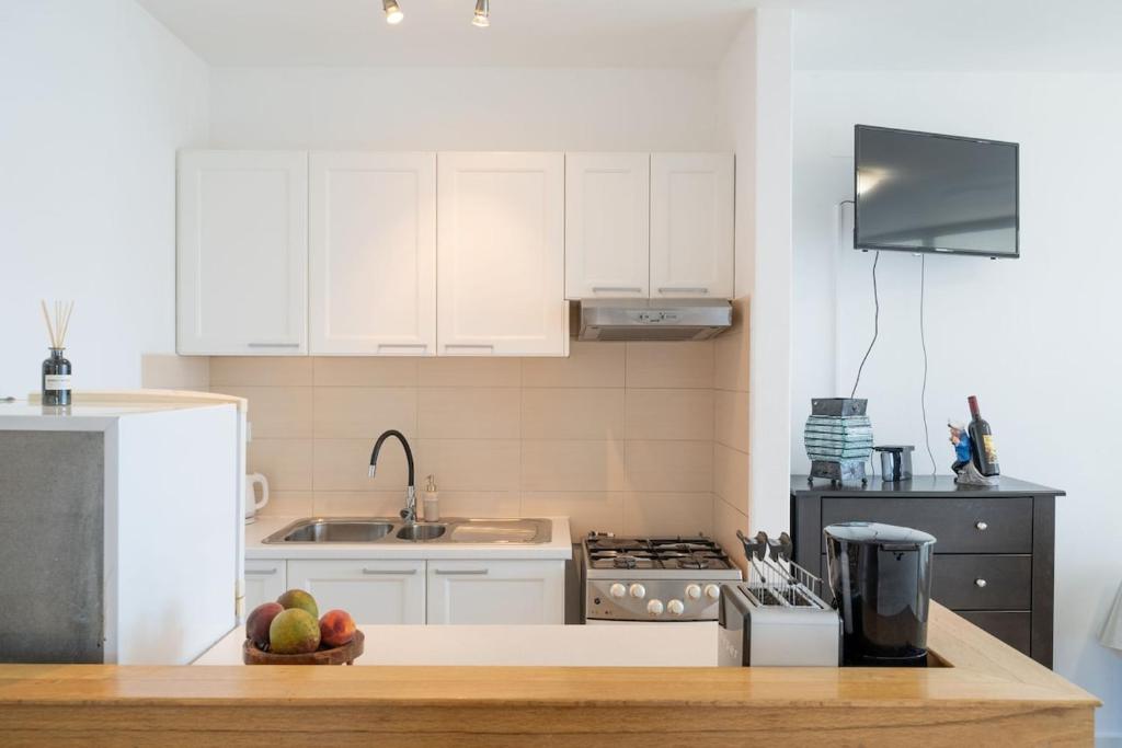 a kitchen with white cabinets and a bowl of fruit on a counter at Prizba Tomas 1 in Blato