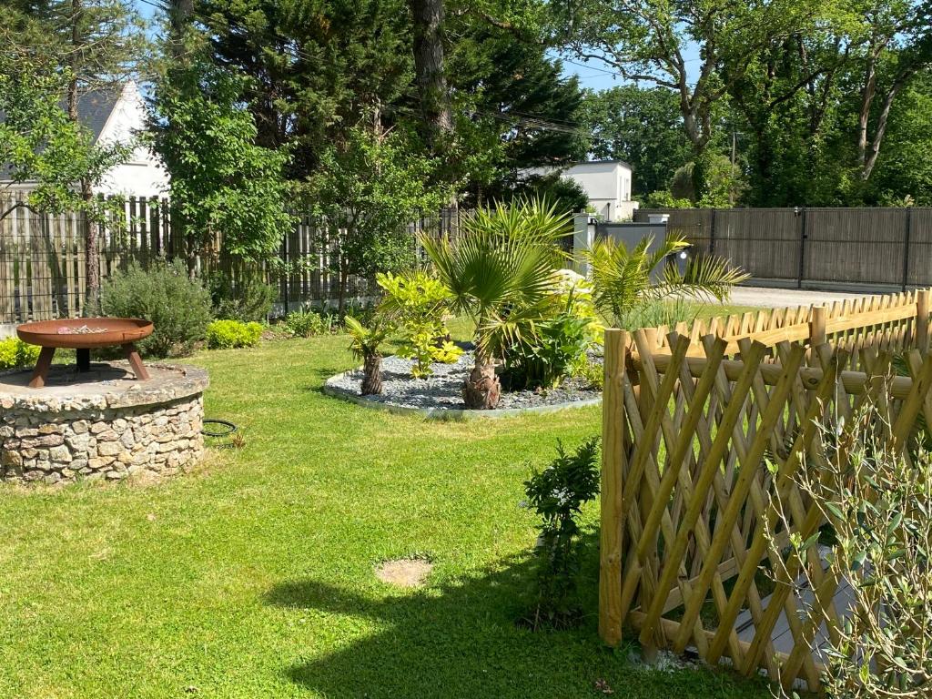 une cour avec une clôture en bois et un banc dans l'établissement T3 rez de jardin, à Pornichet