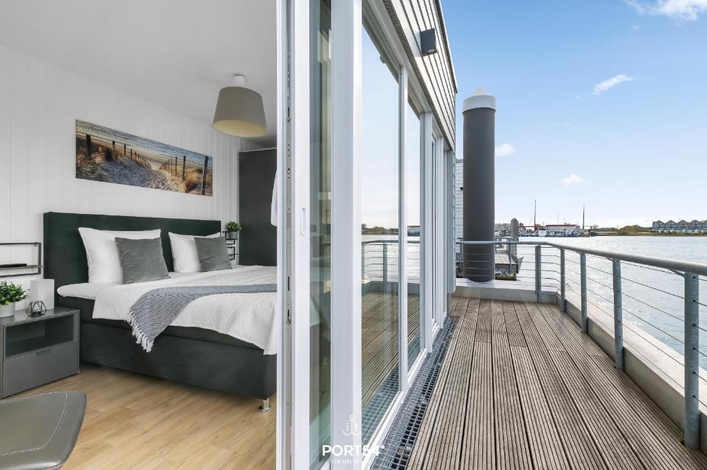 a bedroom with a bed on a balcony at Ferienhaus Am Pier Olpenitz in Olpenitz
