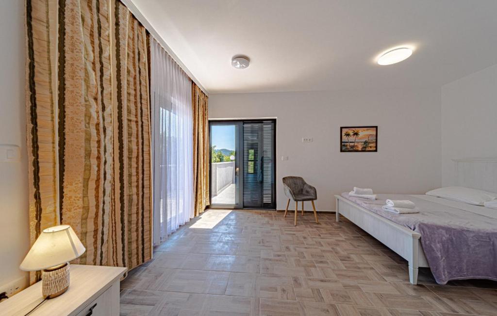 een slaapkamer met een bed en een groot raam bij Villa Angela by Villas Guide in Duba Stonska