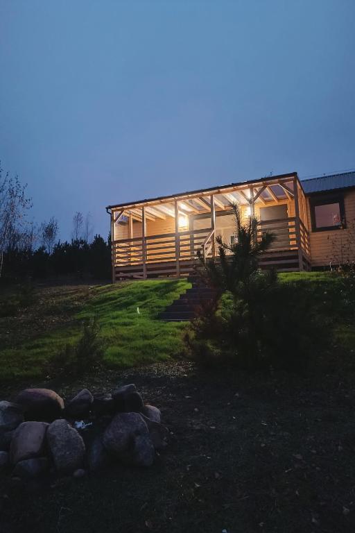 a large wooden house at night with the lights on at Arkadia Borzestowo in Borzestowo