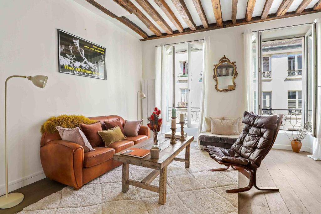 un salon avec un canapé en cuir et une table dans l'établissement Spacieux appartement au Coeur du Marais, à Paris