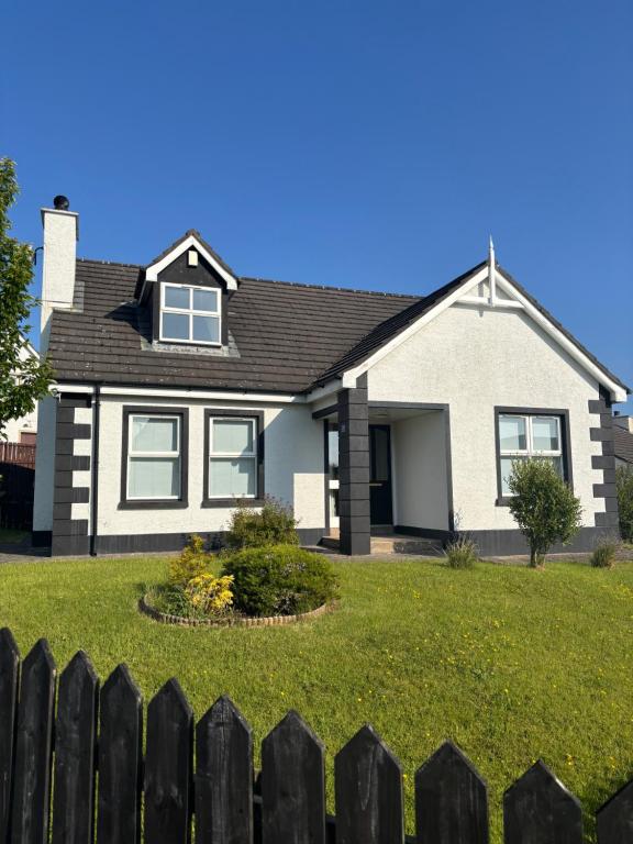 a house with a fence in front of it at Cumberland in Ballycastle
