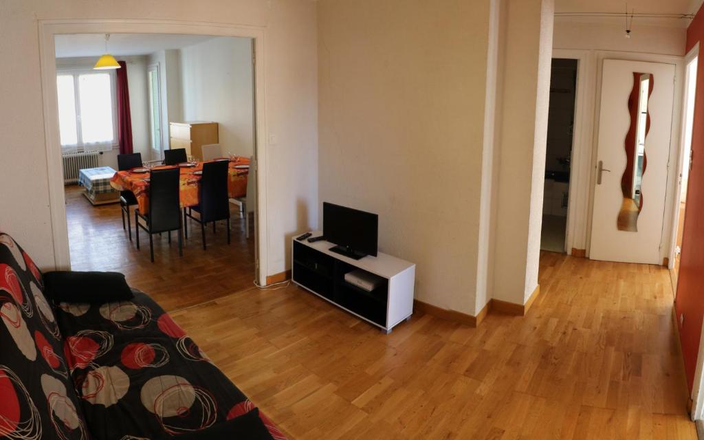 un salon avec un canapé et une télévision sur une table dans l'établissement Grand 3 pièces lumineux à 5 mn à pieds de la vieille ville, à Annecy