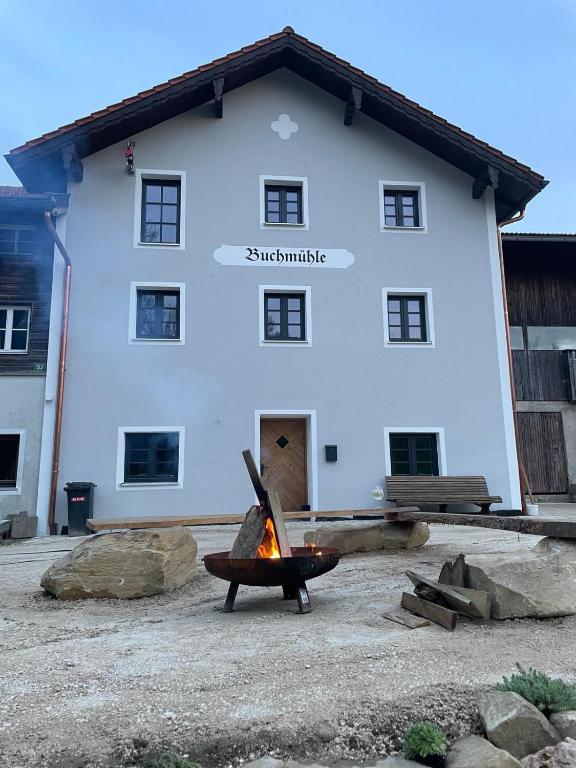 a large white building with a fire in front of it at Buchmühle in Niederdorla