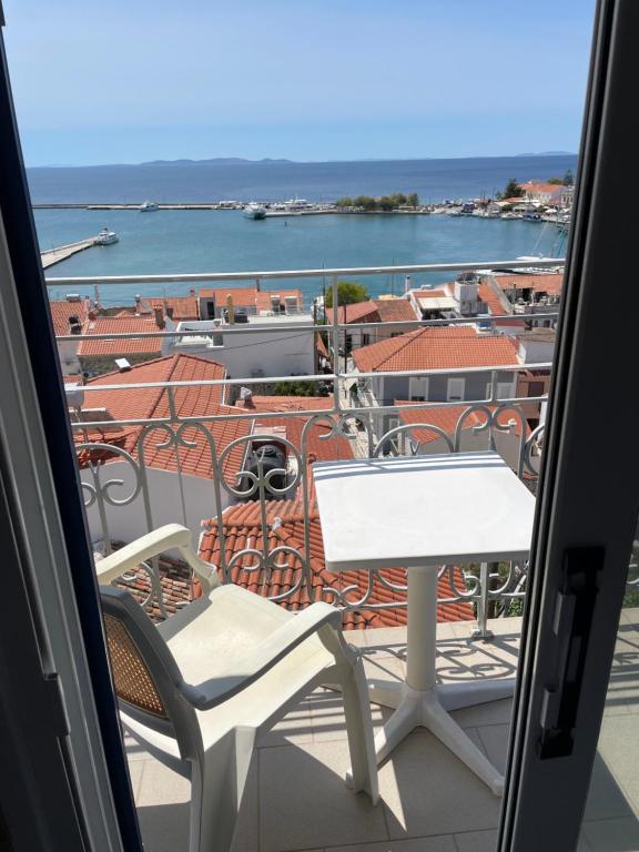 a table and chairs on a balcony with a view at Hotel Antonios in Pythagoreio