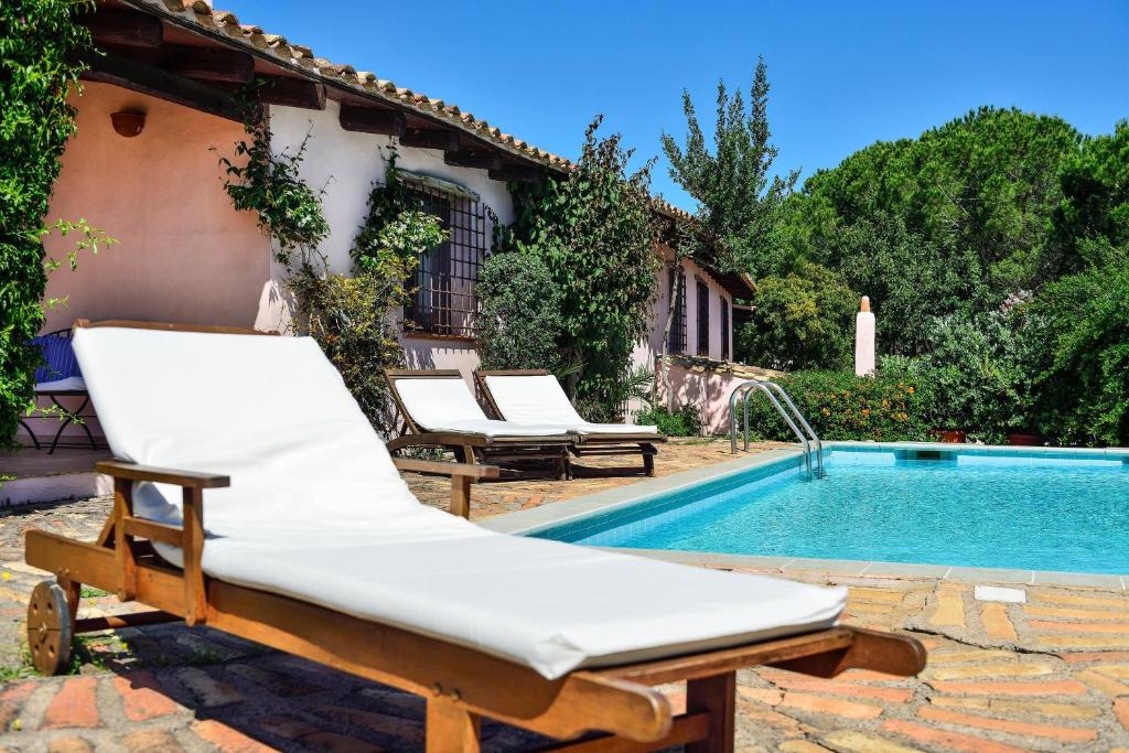 a bed sitting next to a swimming pool at Villa Fiori 3 in Is Molas 