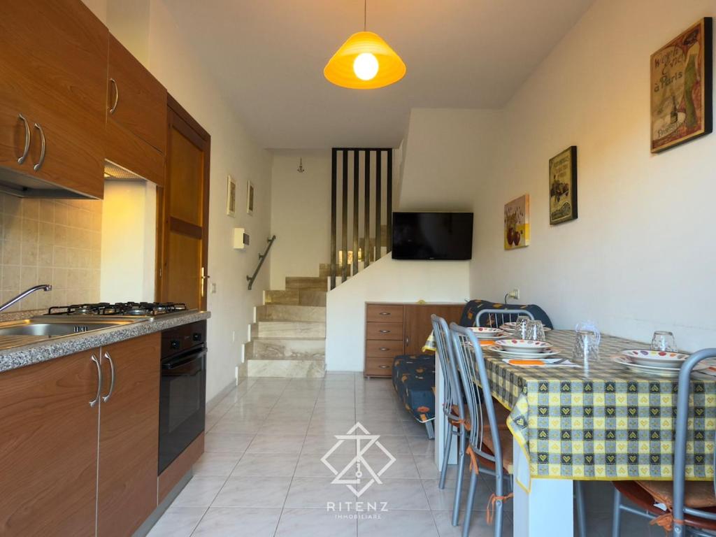 a kitchen with a counter and a table with chairs at Domus Vespro in Villasimius