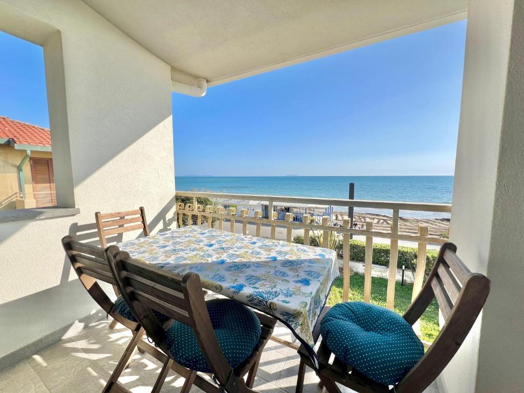 Una mesa y sillas en un balcón con vista al mar. en Rosanna, terrazza vista mare, 2 camere, clima e 2 posti auto a soli 50 m dal mare! by Alfareal, en Castiglione della Pescaia