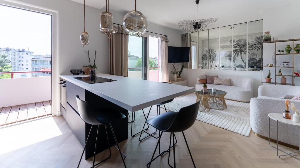 une cuisine et un salon avec une table et des chaises dans l'établissement LE GOLD annecy centre 3 CHAMBRES 100m LAC parking, à Annecy