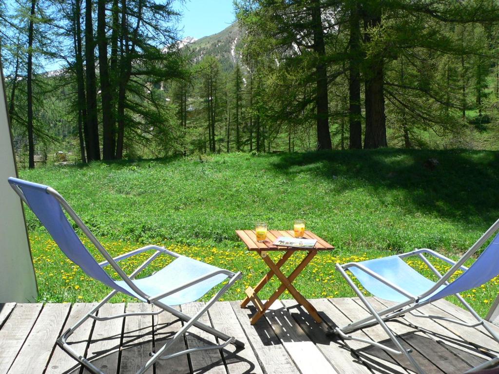 deux chaises et une table avec deux boissons sur une terrasse dans l'établissement Foux d' Allos Les Etoiles, à Allos