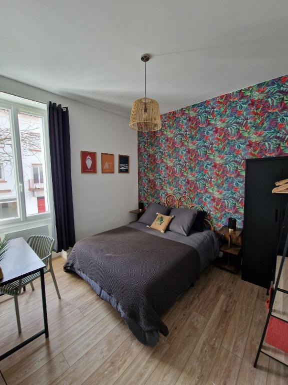 - une chambre avec un lit et un mur coloré dans l'établissement Le Savary appart centre-ville près des Chantiers, à Saint-Nazaire