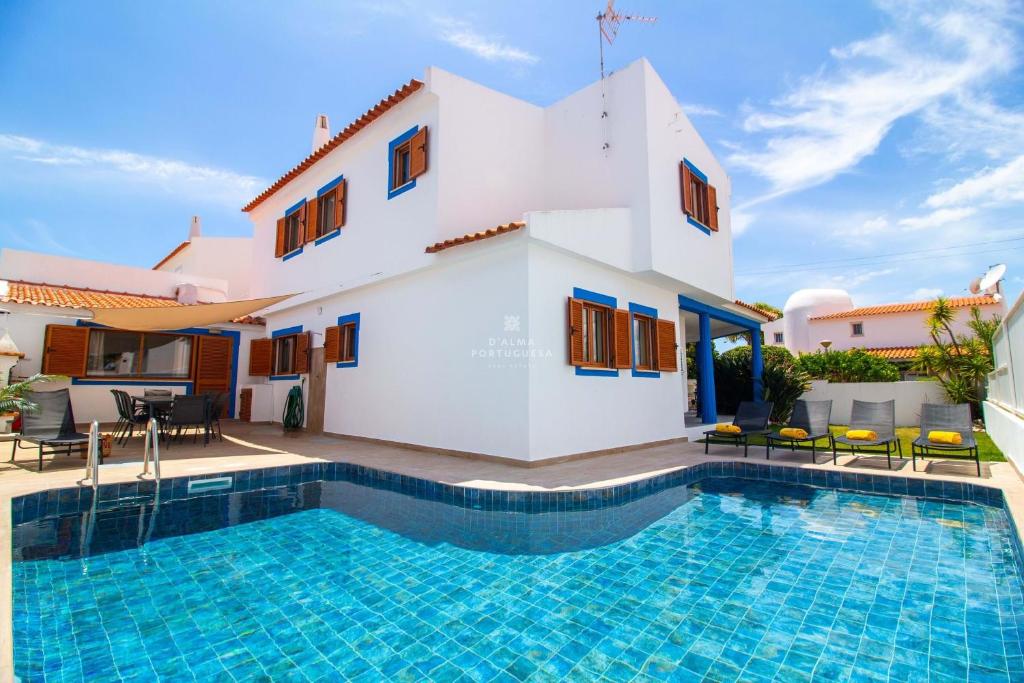 eine Villa mit einem Swimmingpool vor einem Haus in der Unterkunft Villa Girassol - By Dalma Portuguesa in Olhos de Água