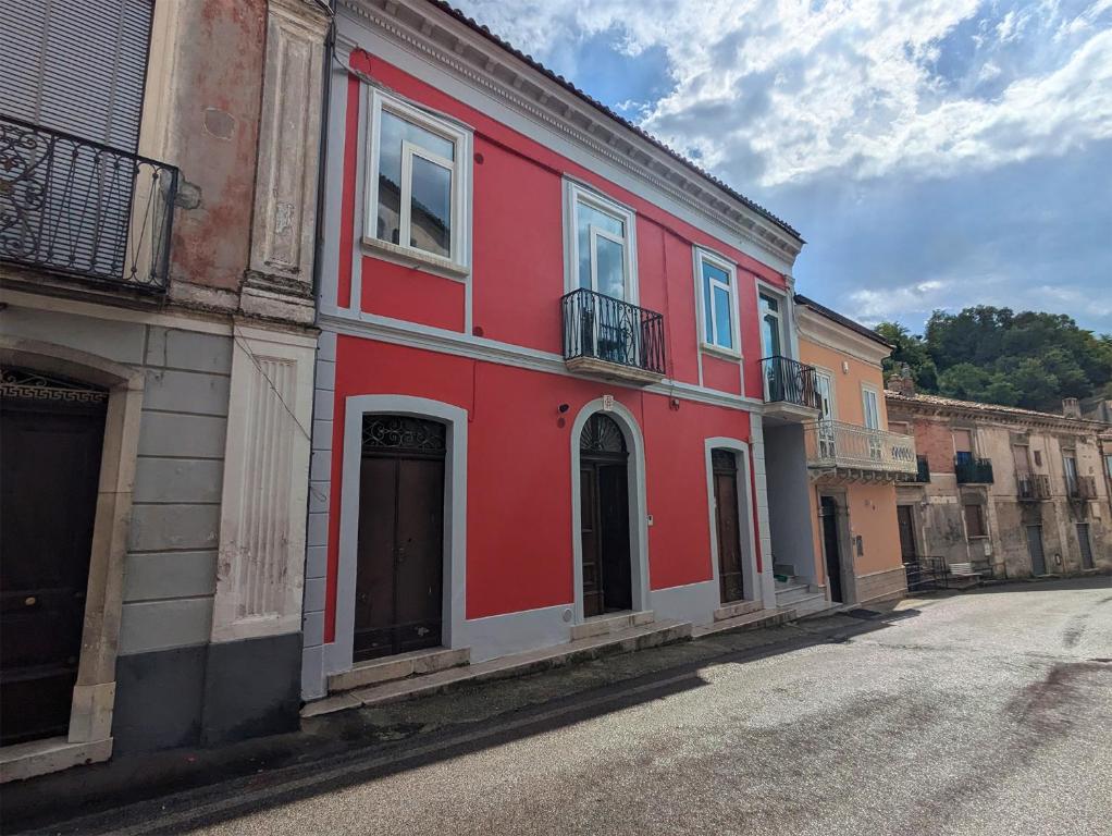 a red building on the side of a street at La casa di nonna in Montesano sulla Marcellana