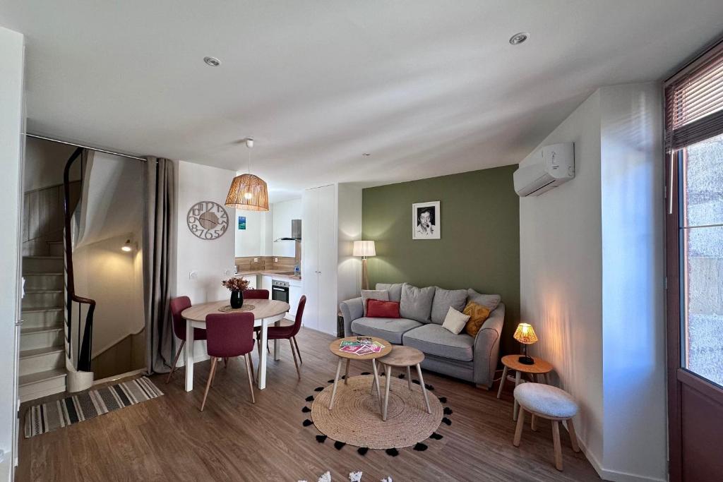 un salon avec un canapé et une table dans l'établissement Casa Majour - Duplex coeur de ville - T2 - Climatisé, à Brive-la-Gaillarde