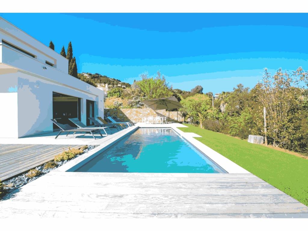 une piscine dans l'arrière-cour d'une maison dans l'établissement Villa de Vacances au Cœur de la Nature, à Cavalaire-sur-Mer