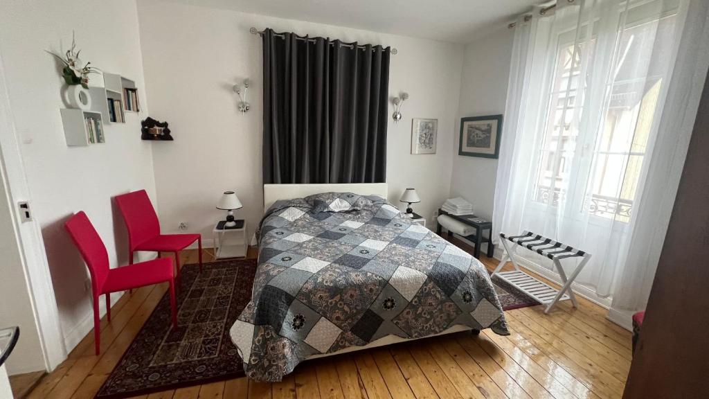 - une chambre avec un lit et deux chaises rouges dans l'établissement Résidence Chez Tante Germaine, à Strasbourg
