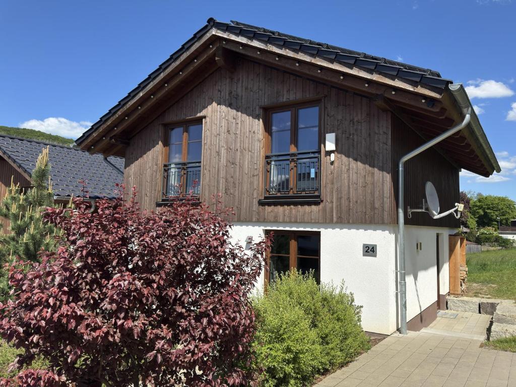a wooden house with windows and a bush at Chalets am Diemelsee in Heringhausen in Heringhausen