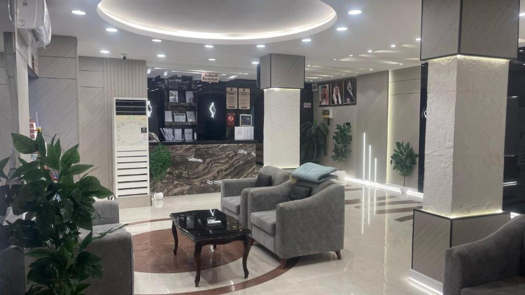 a living room with two chairs and a table at بسمة الفخامة للشقق المخدومة in Abu Arish