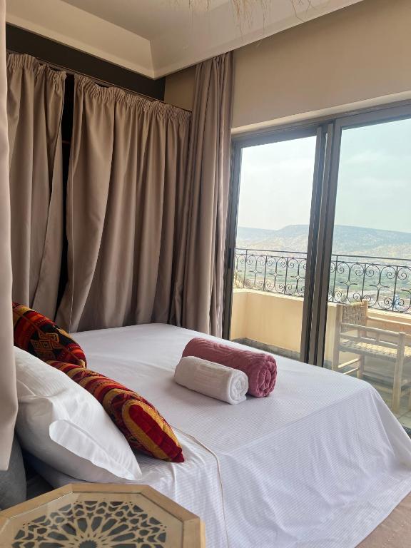 a bedroom with a bed and a large window at SurfAppart Morocco in Tamraght Ouzdar