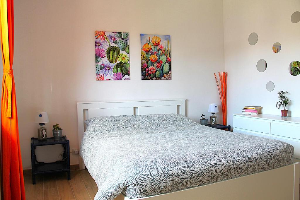 a bedroom with a bed and two paintings on the wall at Casa ViDa Sabaudia in Sabaudia