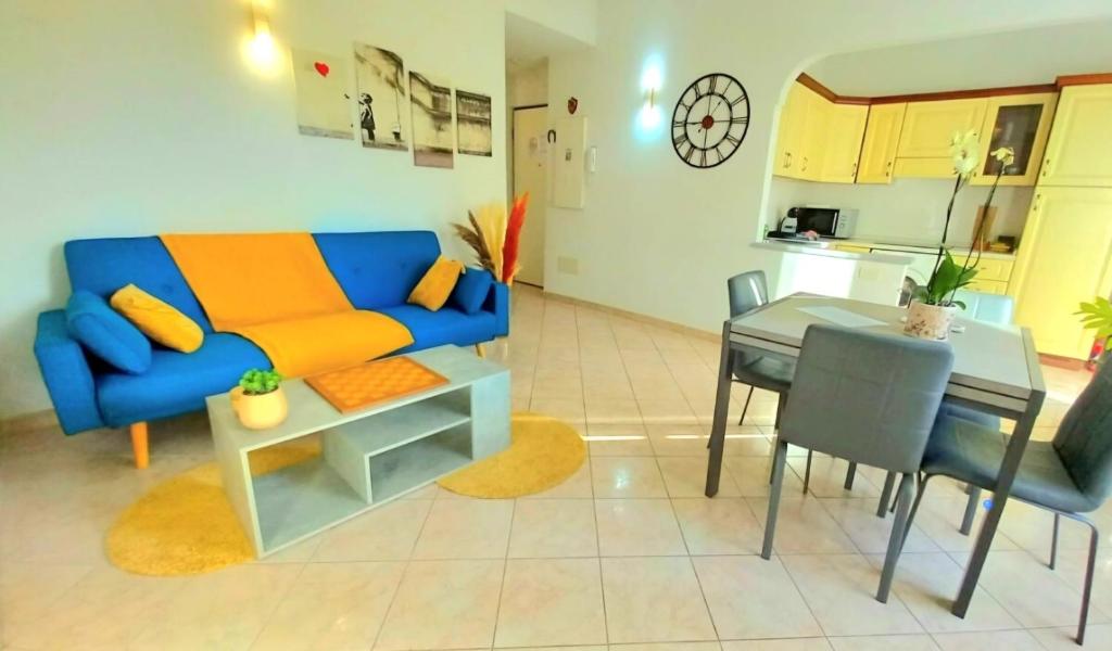 un salon avec un canapé bleu et une table dans l'établissement Trilocale spiaggia 5 minuti a piedi, à Roquebrune-Cap-Martin